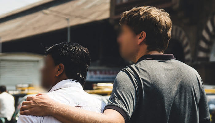 Two investigators in India (Identity obscured) walk down a street together.